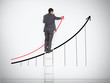 Businessman standing on ladder drawing graph
