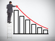 Businessman drawing red line above bar chart