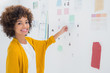 Cheerful designer standing in front of material samples