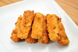 Seven Baked Fish Sticks on a White Plate