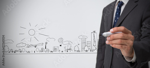Photo: Businessman drawing out a town plan doodle Businessman drawing out a town plan doodle