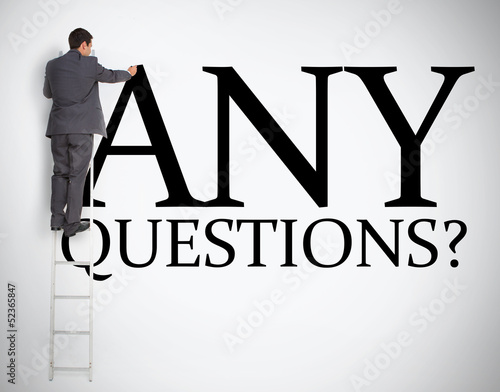 Photo: Businessman standing on ladder finishing large sign Businessman standing on ladder finishing large sign