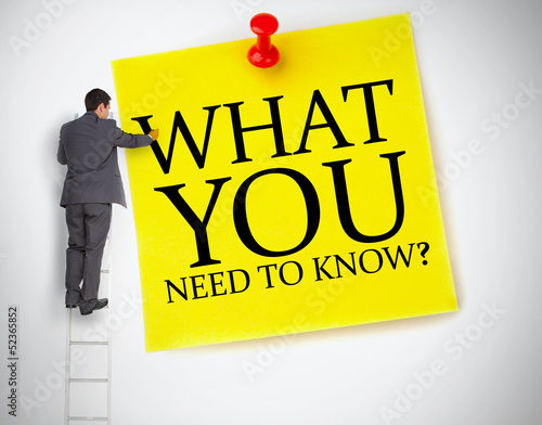 Photo: Businessman standing on ladder writing what you need to know Businessman standing on ladder writing what you need to know