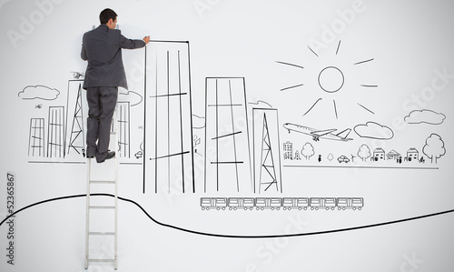 Photo: Businessman drawing skyscrapers on town doodle Businessman drawing skyscrapers on town doodle