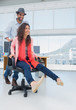 Creative business colleagues having fun on the office chair