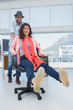 Creative business team having fun on a swivel chair