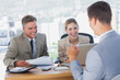 Smiling business people laughing with applicant