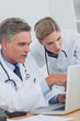 Concentrated doctor pointing at a laptop