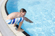 Activities on the pool. Cute boy swimming and playing in water i