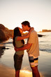 Young couple embracing and kissing each other on the beach