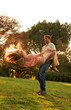 Man revolving girlfriend in a park while he is holding her