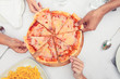 Hands taking slice of pizzas