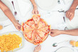 Hands choosing slice of pizza