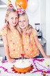 Twins looking at the camera on a birthday