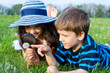 Photo: Kids looking to dandelion with a magnifying glass Kids looking to dandelion with a magnifying glass