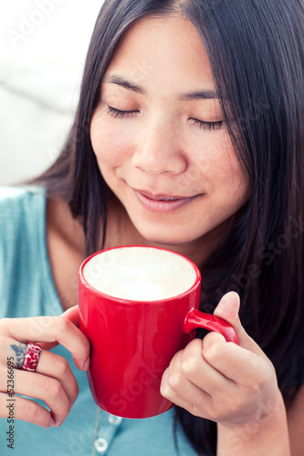 Photo: Attractive asian woman drinking coffee Attractive asian woman drinking coffee