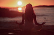 Silhouette of woman doing yoga on the beach