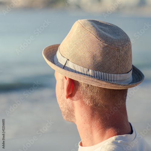 Photo: Relaxed man with a hat on the beach Relaxed man with a hat on the beach