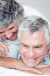 Cheerful retired couple lying together