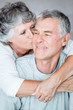 Cheerful mature woman kissing her husband