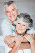 Cheerful retired couple posing together on the bed