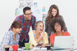 Cheerful team of creative designers working on a laptop