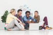 Happy team of creative designers sat on the floor