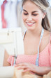 Attractive fashion designer using a sewing machine