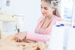 Pretty fashion designer sewing a textile