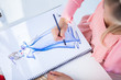 Fashion designer drawing clothes while she is sat at her desk
