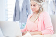 Blonde fashion designer working on a laptop