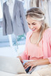 Smiling fashion designer working on her laptop