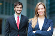 Two smiling business partners in an urban setting