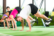 People in sport gym on suspension trainer