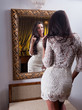 Sensual  womaan in white dress looking mirror with a wine glass