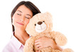 Woman daydreaming with a teddy bear