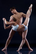 Pair of acrobats posing on dark background