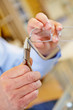 Hand mit Zange repariert Brille