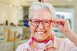 Seniorin mit Brille beim Optiker