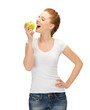 woman in blank t-shirt eating green apple