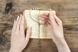 Hands holding the Bible and praying with a rosary