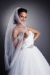 Portrait of smiling bride hiding behind veil