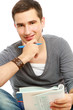 Young man studying on floor and smiling at camera isolated