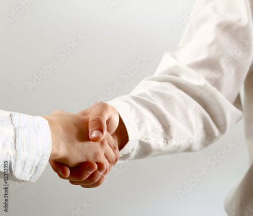Photo: Closeup of a business handshake, isolated on white Closeup of a business handshake, isolated on white