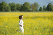 Foto: Frau läuft durch Blumenwiese. Frau läuft durch Blumenwiese.