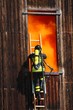 brave firefighters with oxygen cylinder goes into a house throug