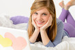 Young girl lying on bed with laptop