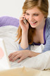 Cheerful teenage girl with phone and laptop