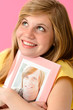 Teenage girl embracing picture of her boyfriend