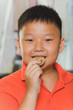 Photo: Young asian boy eats a piece of biscuit Young asian boy eats a piece of biscuit
